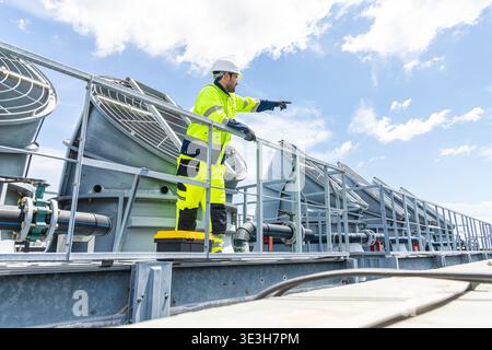 Professional Worker Servicing HVAC Modern office building Cooling tower, Industry Large Air conditioner system expert team service. Stock Photo