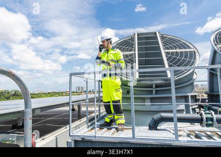 Professional Worker Servicing HVAC Modern office building Cooling tower, Industry Large Air conditioner system expert team service. Stock Photo