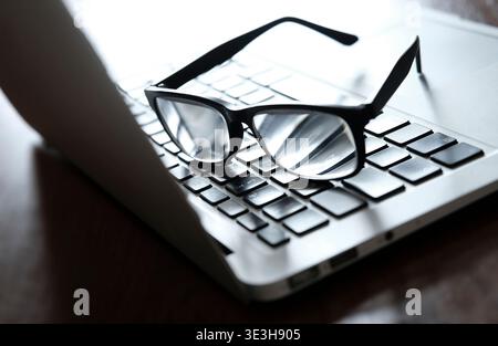 reading glasses on laptop computer keyboard Stock Photo