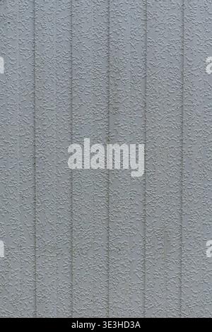 Close up of a grey wall surface with fine textured relief and vertical lines. Stock Photo