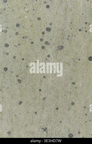 Close up of a light concrete surface with small dark spots and grainy texture. Stock Photo