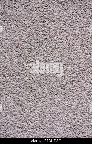 Close up of a light beige stucco wall with fine grain and rough surface texture. Stock Photo