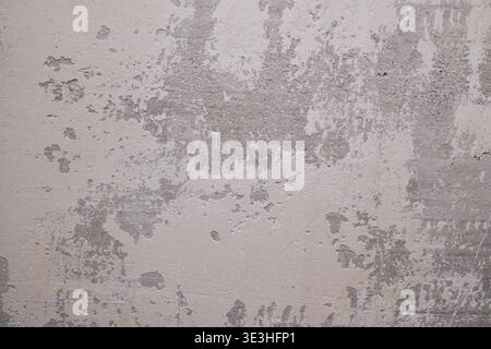 Textured Surface with Visible Paint Peeling and Worn-Out Plaster Revealing Underlying Layers Stock Photo