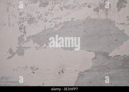 Textured Wall Surface with Peeling Paint and Exposed Layers of Material in Neutral Tones Stock Photo