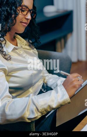 detailed image of woman writing on clipboard during professional meeting with soft illumination Stock Photo