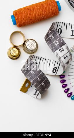 Different tools and materials for sewing and crafting are arranged on a table for use Stock Photo