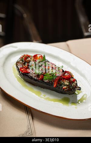 Roasted eggplant with herbs and chili on plate Stock Photo