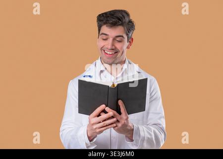 Doctor man reading book with focused view on beige. Discovery, education time Stock Photo