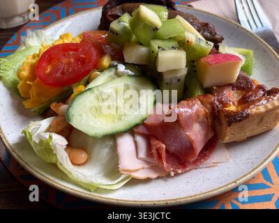 Hotel breakfast buffet in Rome, Italy. Serving scrambled eggs, cured meats, fruit, and quiche from an international selection. Stock Photo