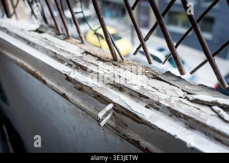 Weathered old wooden window frame ledge with chipped paint and worn wood. Cracks and peeling surfaces, carpentry and joinery Concept of decay and nost Stock Photo