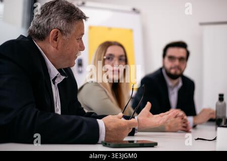 Business professionals engaging in a collaborative discussion during a meeting in a modern office setting Stock Photo