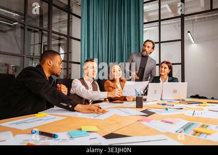 Group of people discussing ideas in a modern office setting during a business meeting in the afternoon Stock Photo