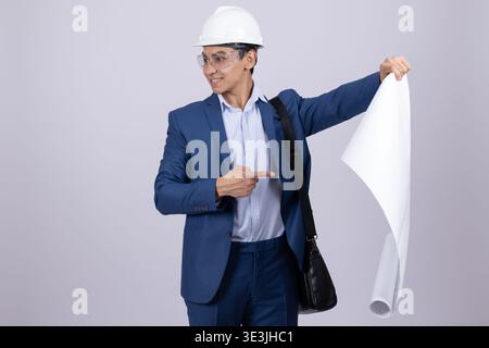 Architect holding large blueprints and wearing helmet Stock Photo