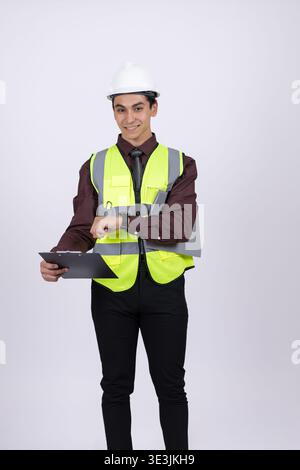 Worker in safety vest holding a tablet on white background Stock Photo