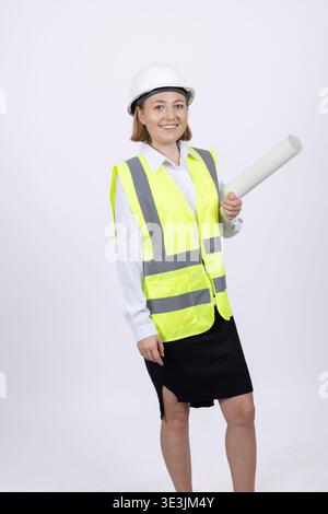 Female engineer in safety helmet holding a white blueprint Stock Photo