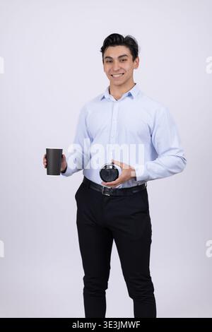 Young man holding a camera and a roll of film in the studio Stock Photo