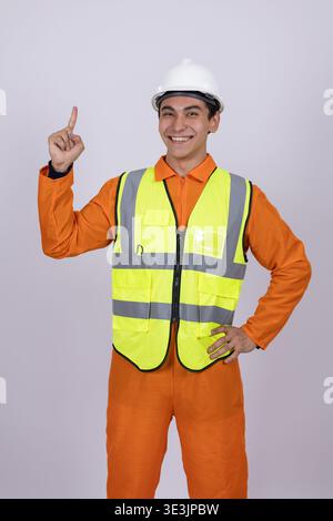 Construction worker in orange uniform pointing up in the studio Stock Photo