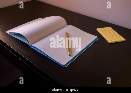 Open notebook with pencil on dark table Stock Photo