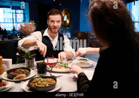 Couple dining together in an elegant restaurant at night Stock Photo