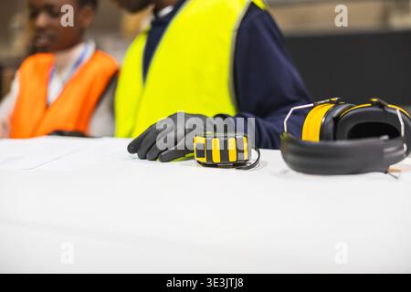 Construction workers reviewing plans and safety gear Stock Photo