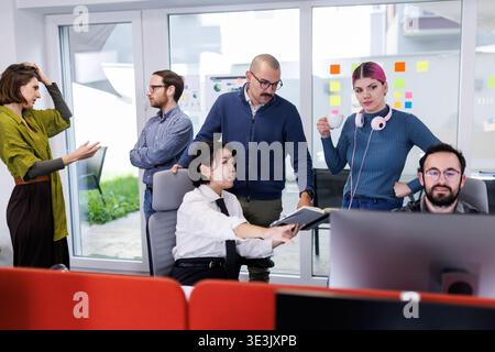 Business team collaborates in modern office space discussing ideas and strategies during a productive work session Stock Photo