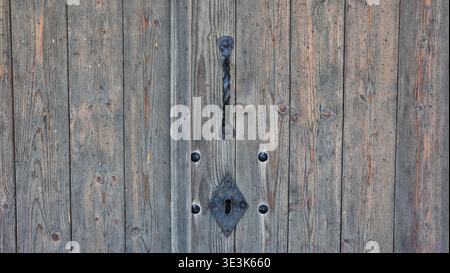Rusty antique keyhole on old wooden door texture Stock Photo