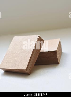 Minimalist scene featuring square cardboard boxes stacked in vertical columns on a clean white table. Ideal for concepts like packaging, storage Stock Photo
