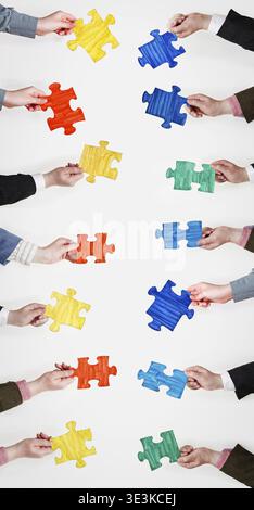 Put painted puzzle pieces in human hands on a gray background Stock Photo