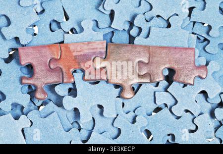 A few pieces connected together in a pile of separate puzzles Stock Photo