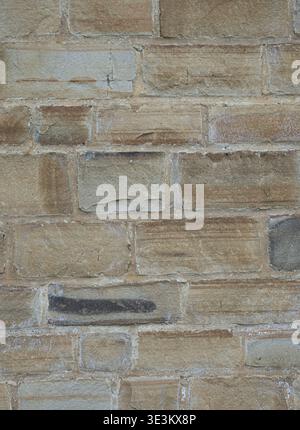 Close-up of a natural stone wall with varied tones and rustic texture. Stock Photo