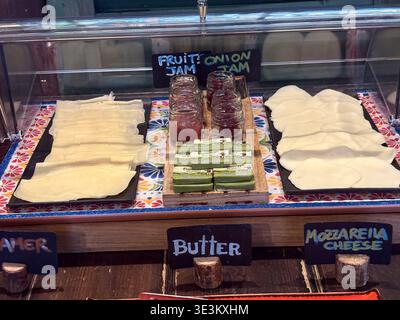 Sliced cheeses, butter, and fruit jam at a hotel buffet breakfast in Rome, Italy. Italian breakfast staples displayed. Stock Photo