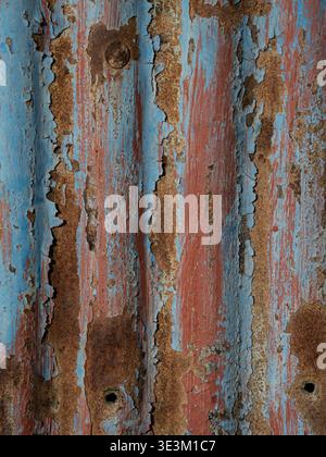 Vibrant metal surface featuring blue paint and rust creating a bold textured background. Stock Photo