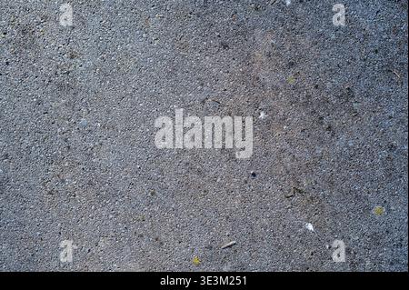 Gray concrete tile texture with small pores and embedded stones, abstract industrial background, neutral surface for design, construction material and Stock Photo
