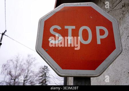 Close-up of a red octagon stop sign with weathered texture on a blurred background Stock Photo