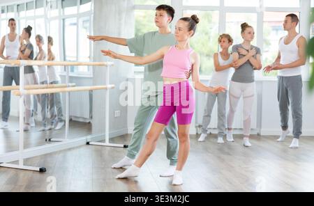 Ballet studio - teenagers girls and boys learn ballet movements in pairs Stock Photo