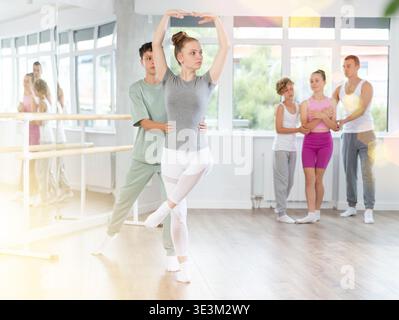 Ballet studio - teenagers girls and boys learn ballet movements in pairs Stock Photo