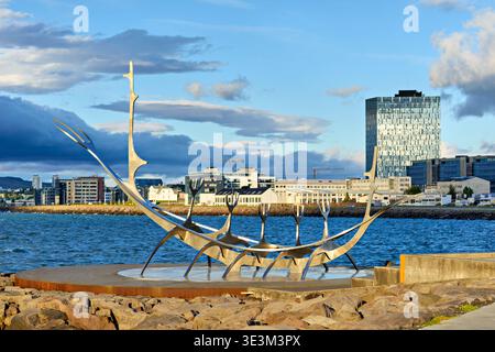 The Sun Voyager sculpture in Reykjavik near the water while the city skyline is displayed against the sky. Stock Photo