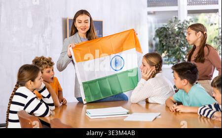Female teacher working with students in school class, talking about national flag of India at history lesson Stock Photo