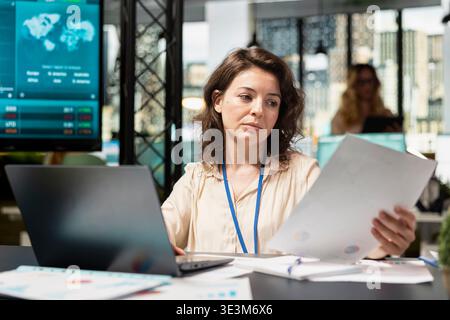 Focused businesswoman working on strategic thinking at the company office, establishing goals with determination. Ambitious chief executive officer reviewing data insights on laptop. Stock Photo