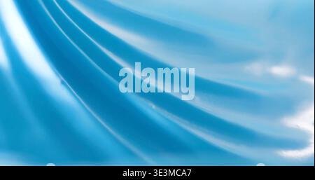 Bright blue fabric with smooth texture and soft folds under light in indoor setting Stock Photo