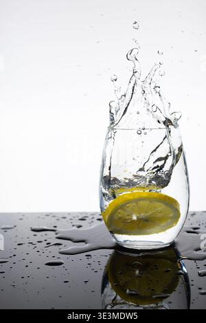 Lemon Slice Splashing into Glass of Water – Fresh Citrus Motion Shot Stock Photo