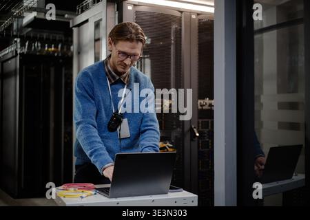 Middle Aged Caucasian Man Managing Server Maintenance Tasks Using Laptop Computer Stock Photo