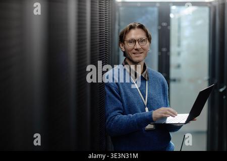 Portrait of Middle Aged Caucasian Man Using Laptop in Data Center Stock Photo
