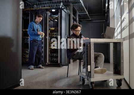 Young Adult Men Working with Server Equipment in Modern Data Center Stock Photo
