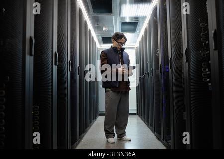 Young Adult Asian Man Using Digital Tablet While Working in Data Center Stock Photo