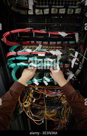 Man Configuring Network Cables in Data Center Rack Stock Photo