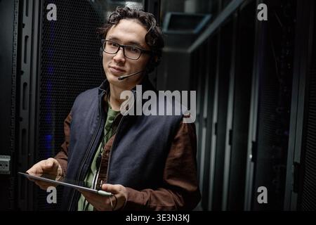 Portrait of Young Adult Asian Man Working with Tablet in Server Room Stock Photo