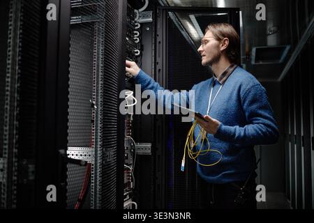 Caucasian Adult Man Managing Server Equipment in Data Center Facility Stock Photo