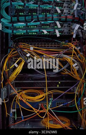 Network Server Rack Displaying Colorful Ethernet Cables and Blinking Lights Stock Photo
