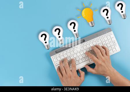 Top view of hands typing on a keyboard with a glowing idea bulb among question mark bulbs on blue background, symbolizing brainstorming, search, FAQ, Stock Photo